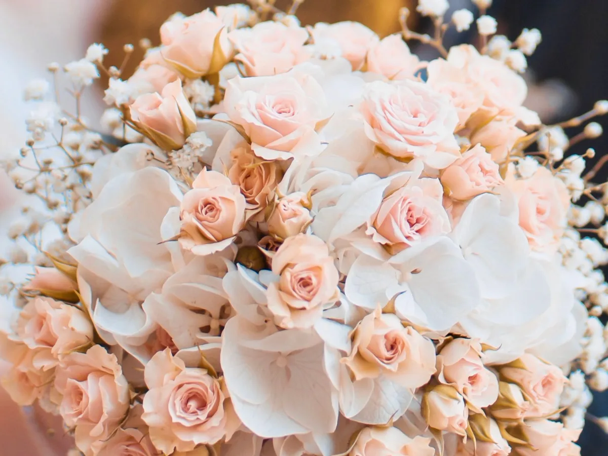 Brautstrauß aus zartrosa Rosen und Hortensien im warmen Abendlicht
